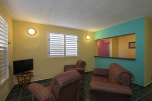 Wohnzimmer im Gran Caribe Villa Tortuga Hotel mit Fernseher und Sesseln.
