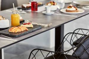 Frühstückstisch im Poseidon of Paros Hotel & Spa mit verschiedenen Speisen und Getränken.