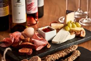 Poseidon of Paros Hotel & Spa Speiseplatte mit Käse, Fleisch, Wein und Brot.