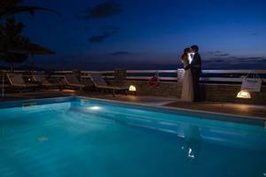 Brautpaar beim Kuss am Pool bei Nacht im Pyrgaki Hotel