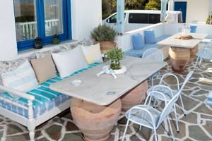 Die Terrasse des Pyrgaki Hotels mit Möbeln, Kissen und Pflanzen.