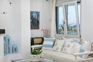 Wohnzimmer des Pyrgaki Hotels mit Blick auf das Meer und eine offene Terrasse.