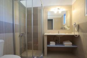 Badezimmer im Pyrgaki Hotel mit Dusche, Waschbecken und Toilette