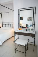 Schlafzimmer mit Bett, Kommode und Spiegel im Pyrgaki Hotel.