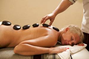 Eine Frau im Hotel Lella Baya & Thalasso genießt eine entspannende Steinmassage.