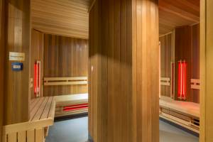 Innenansicht der Sauna im Leonardo Hotel Amsterdam Rembrandtpark mit Holzwänden und Bänken.