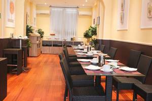 Frühstücksbereich des San Marco Hotels mit gedeckten Tischen und Stühlen.
