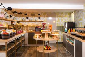 Frühstücksraum im Leonardo Boutique Hotel Rome Termini mit verschiedenen Speisen und Getränken.