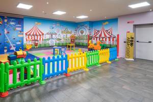 Spielbereich für Kinder im A.Roma Lifestyle Hotel mit bunten Spielgeräten und einer bunten Wandgestaltung.