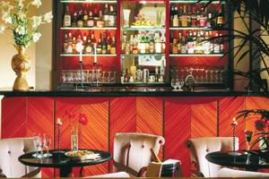 Innenansicht der Bar des Dei Mellini Hotels mit gefüllten Gläsern, Kerzen und einem Tisch mit Essen.