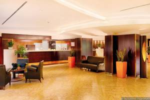 Lobby des NH Roma Villa Carpegna Hotels mit Rezeption, Sofas, Sesseln und Pflanzen