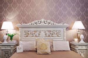 Metropole Hotel Schlafzimmer mit kunstvollen Bettkopfteil und Dekoration.