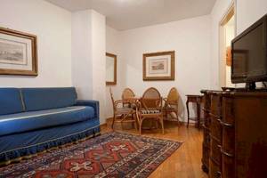 Wohnzimmer des San Marco Palace Hotels mit blauem Sofa, Esstisch und Fernseher