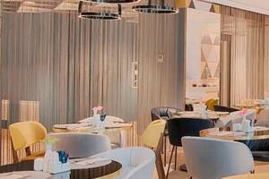 Innenansicht des Restaurants im Avani Rio Novo Hotel mit runden Tischen und Stühlen.