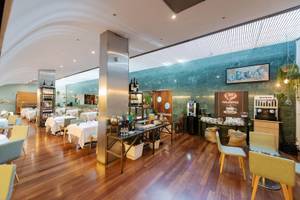 Frühstücksraum des Atenea Barcelona Aparthotel mit Holzboden und grünen Wänden.