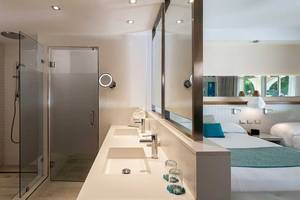 Hotelbadezimmer mit einer Dusche und einem Doppelwaschbecken.