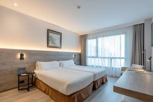 Zimmer im Attica 21 Barcelona Mar mit zwei Betten, Schreibtisch und großem Fenster.