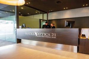 Rezeptionsbereich des Hotels Attica 21 Barcelona Mar mit zwei Mitarbeitern und einem großen Logo.