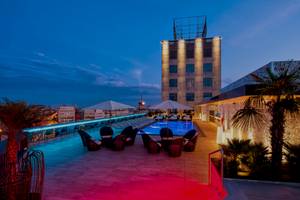Terrasse des Catalonia Bayahibe Hotels bei Nacht mit Swimmingpool und Lounge-Sesseln