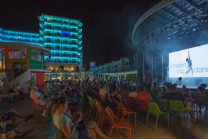 Nachtshow vor dem Azura Deluxe Resort & Spa Hotel mit vielen Besuchern auf Stühlen.