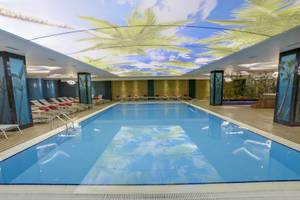 Innenpool des Azura Deluxe Resort & Spa mit tropischem Deckendesign.
