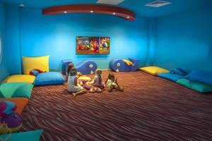 Kinderspielzimmer im Azura Deluxe Resort & Spa mit bunten Kissen und Fernseher