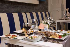 Restauranttisch im Delphin Deluxe Hotel mit Gerichten, Gläsern und Zubehör.