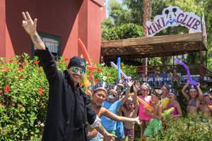 Gruppe von Kindern und einem Mann in Piratenkostümen vor dem Delphin Deluxe Hotel.