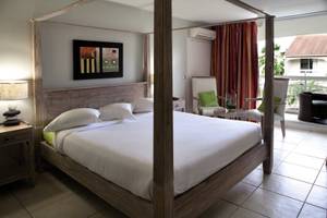 Schlafzimmer im La Pagerie - Tropical Garden Hotel mit einem Himmelbett, Kissen und einer Lampe