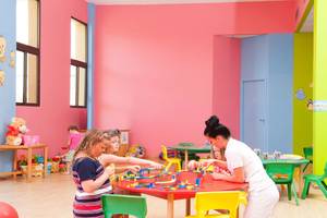 Kinder spielen in einem farbenfrohen Spielzimmer im Constantinou Bros Athena Beach Hotel.