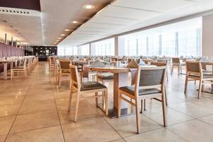 Innenansicht des Restaurants im Beach Club Font de Sa Cala mit vielen Tischen und Stühlen.
