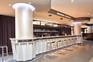 Die Bar im Beach Club Font de Sa Cala mit modernen Stühlen und einer großen Theke.