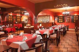 Innenansicht des Restaurants im Arabia Azur Resort mit roten Wänden und gedeckten Tischen.