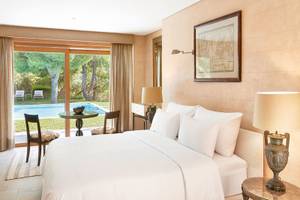 Schlafzimmer im Cape Sounio Grecotel Resort mit Blick auf den Pool und Garten