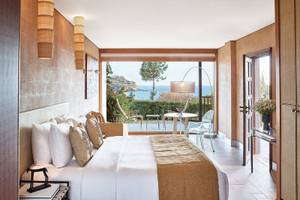 Schlafzimmer im Cape Sounio Grecotel Resort mit Blick auf das Meer und die Terrasse
