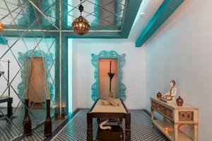 Behandlungsraum im Sultan of Dreams Hotel Spa mit Liege, Tisch, Buddha-Statue und blauen Wandverkleidungen.