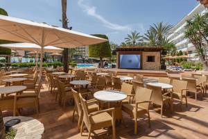 Außenbereich des Aparthotels Marins Playa mit Sitztischen und Sonnenschirmen.