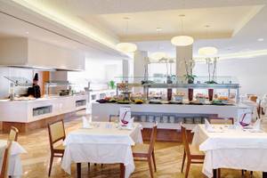 Restaurant im Hipotels Dunas Cala Millor mit Buffet und gedeckten Tischen.