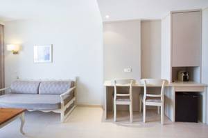 Hotelzimmer im Bakour Garbi Cala Millor mit einem Sofa, Schreibtisch und zwei Stühlen.