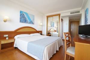 Doppelzimmer im Hotel Millor Sol mit zwei Betten, Schreibtisch, Fernseher und offenem Badezimmerspiegel.