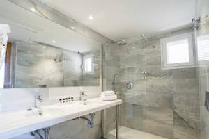 Badezimmer des Millor Sol Hotels mit Doppelwaschbecken, Dusche und Toilette