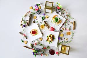 Frisch zubereitete Gerichte im TIA Wellness Resort, umgeben von Blumen und Kerzen.