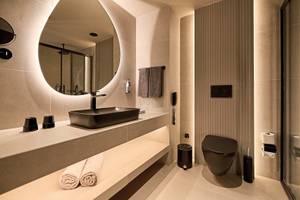 Badezimmer im Aldiana Club Side Beach mit runden Spiegel und luxuriöse Ausstattung.