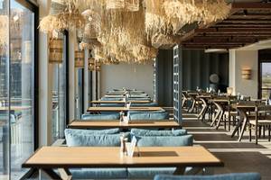 Innenansicht des Restaurants im Aldiana Club Side Beach mit blauen Stühlen und Tischen.
