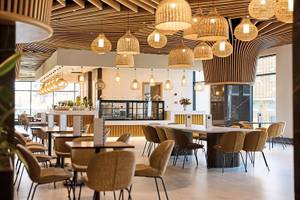 Innenbereich des Aldiana Club Side Beach mit Esstischen, Stühlen und dekorativen Lampen.