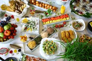 Frühstücksbuffet im TIA Wellness Resort mit verschiedenen Früchten, Brot, Käse und weiteren Speisen.