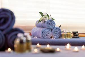 Spa-Behandlungsbereich im Sherwood Exclusive Kemer Hotel mit Handtüchern, Kerzen und ätherischen Ölen.