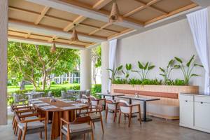 Terrassenrestaurant des Sherwood Exclusive Kemer Hotels mit Tischen, Stühlen und Pflanzen