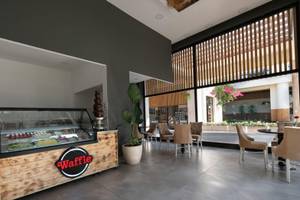 Innenansicht der Waffel Bar im Sherwood Exclusive Kemer Hotel mit einer Waffel Theke und freien Tischen
