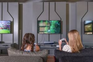 Zwei Kinder spielen Videospiele im Sherwood Exclusive Kemer Hotel.